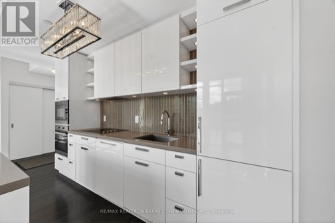 White kitchen with Miele appliances, mosaic backsplash and island